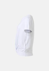 Blouse blanche à manches courtes avec un détail de nœud torsadé à l'ourlet avant, vue de côté sur un fond uni.