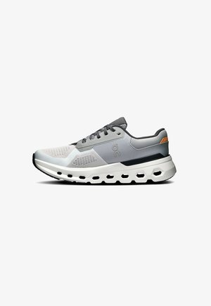 Gray and white athletic shoe with mesh upper, textured accents, and logo detail. Thick sole features cutouts for flexibility and support.