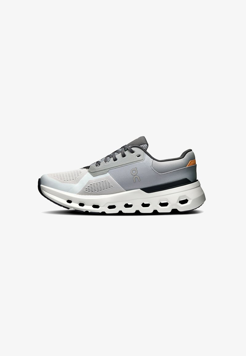 Baskets de sport grises et blanches avec tige en maille, accents texturés et détail de logo. La semelle épaisse présente des découpes pour plus de flexibilité et de soutien.