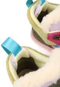 Buty z miękkim beżowym wyściółką i zielonym zewnętrznym materiałem, z różowymi akcentami i niebieskimi pętlami na górze, które ułatwiają zakładanie.