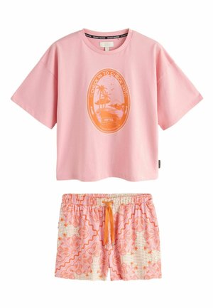 Rosa kurzärmeliges Hemd mit orangefarbenem ovalem Strandmotiv mit der Aufschrift „Check In to Check Out“, kombiniert mit rosa und orange gemusterten Shorts mit Kordelzug.