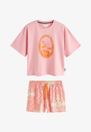 Różowa koszula z krótkim rękawem z pomarańczową owalną grafiką plażową z napisem „Check In to Check Out”, połączona z różowo-pomarańczowymi, wzorzystymi szortami ze sznurkiem.