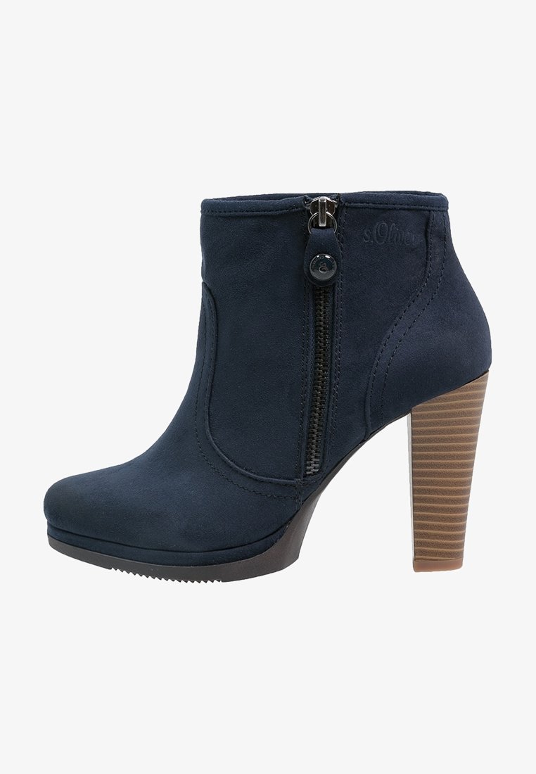 Botte chelsea marine à la finition en suède texturé, avec zip latéral et un talon haut rayé pour plus de hauteur.