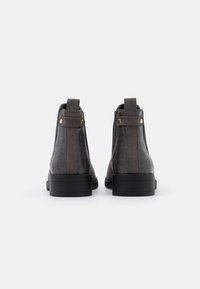 Donkergrijze enkellaarsjes met een gestructureerd nep-krokodillenleer ontwerp, elastische zijpanelen en zwarte rubberen zolen. Verstevigde achterste aantrekstangen.