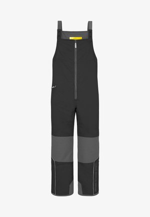 Schwarze und graue Latzhosen mit verstellbaren Trägern, Frontreißverschluss und kontrastierendem Design entlang der Beine. Mit reflektierenden Akzenten.