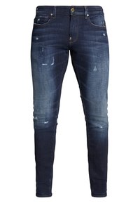 Slim Jeans aus dunkelblauem Denim mit ausgewaschenen Stellen und abrasiven Details. Verfügt über ein klassisches Fünf-Taschen-Design und ein goldenes Knopf.