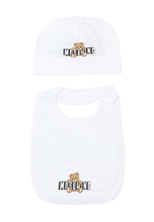 Set di cappellino e bavaglino bianchi per neonati, ciascuno con un orsetto marrone e il testo "Moschino" in bianco e nero sullo sfondo.