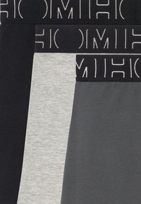 Tre paia di boxer neri, grigi e grigio scuro, con elastici in vita e loghi stampati in colori a contrasto.