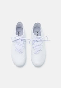 Scarpe da ginnastica bianche con una superficie testurizzata, dettagli in rete e lacci piatti. Presentano una punta arrotondata e una soletta ammortizzata per il supporto.
