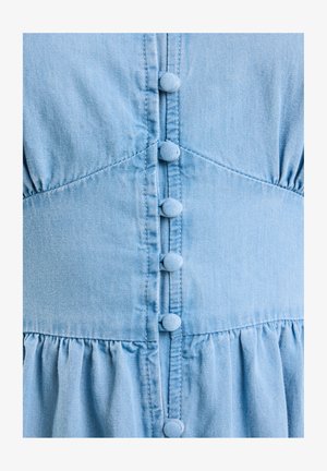 Világoskék farmerruha gombos zárással, hat anyaggal borított gombbal, ráncolt anyaggal a deréknál és texturált felülettel.