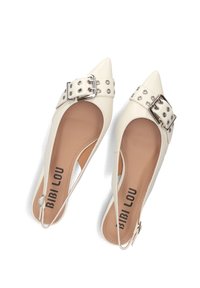 White pointed-toe slingback shoes with a wide buckle and stud detailing. Smooth leather upper, tan insole with "BIBI LOU" branding.