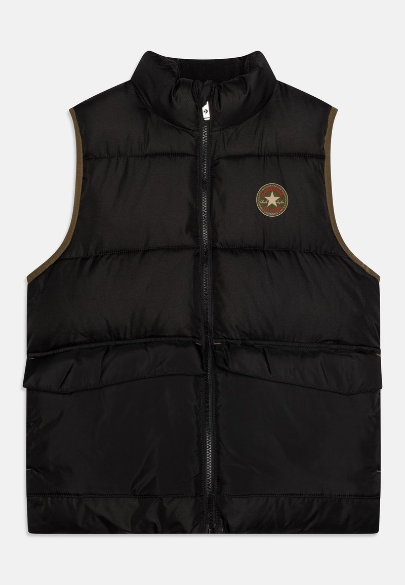 Veste noire matelassée sans manches avec fermeture éclair à l’avant, col montant, ouvertures de poches latérales et patch rond avec logo sur le côté gauche de la poitrine.