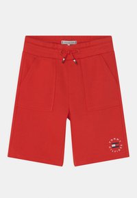 Calças curtas de algodão vermelhas com cintura el�ástica, detalhes de cordão, dois bolsos frontais e uma impressão de logotipo na parte inferior da perna esquerda.