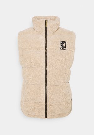 Gilet en polaire beige avec un col montant, fermeture éclair à l'avant et logo KANI noir. Surface texturée avec un design rembourré, sans manches et coupe décontractée.