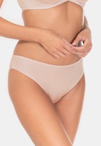 Jasno beżowe, bezszwowe figi bikini o gładkiej fakturze i wysokich wycięciach nogawek, z prostym fasonem pasa.