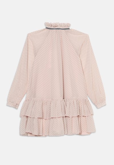 Robe rose pâle à manches longues avec de petits pois noirs, col à volants, poignets froncés et deux volants superposés à l’ourlet.