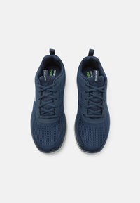 Navy blue athletic shoes with mesh upper, lace closure, pull tab, and light gray rubber sole. Features minimalistic design with ventilation holes.