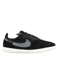 Black suede and mesh athletic shoe featuring a gray Nike swoosh, textured accents, gray rubber sole, and a lace-up design.