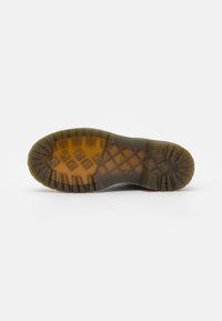 Semelle en caoutchouc avec un motif de semelle robuste, de couleur marron avec des accents transparents, conçue pour l'adhérence et la durabilité.