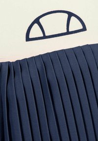 Tela de un tono azul marino con pliegues y líneas texturizadas, que presenta un diseño bordado en forma redondeada en la parte superior en un azul oscuro contrastante.