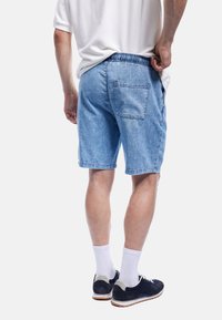 Hellblaue Denim-Shorts mit lockerer Passform, elastischem Bund und einer Gesäßtasche. Mit einem säumten Rand und lässigem Design.