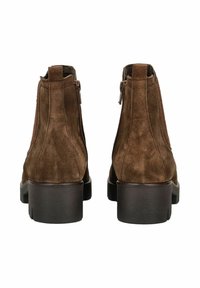 Bottines en daim marron avec un léger talon et des zips à l'arrière. Texture lisse avec un design minimaliste, sans embellissements supplémentaires.