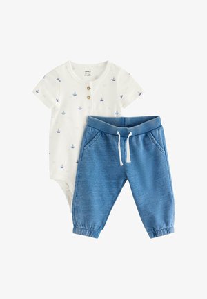 Hvid babybody med små blå sejlbådsprints og træknapper, kombineret med blå joggebukser med elastik i taljen og snørebånd.