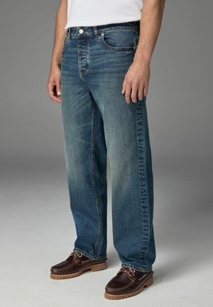 Bureau blauwe denim jeans met een vervaagde afwerking, voorzien van vijf zakken, een knoop- en ritssluiting, en gestikte details langs de naden.