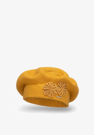 Beret amarilla de punto con dos apliques florales de cuero, textura suave, forma redonda, con una pequeña etiqueta de logotipo metálico en el lateral.