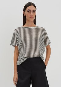 Zwart-wit gestreepte korte mouw top, lichte geweven stof, brede halslijn, losse pasvorm, gecombineerd met zwarte broek.