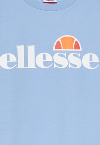 Sudadera de color azul claro hecha de un tejido suave, con un logo blanco y un diseño de medio círculo colorido en naranja y rojo sobre el logo.