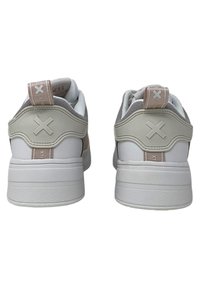 Zapatillas blancas con acentos texturizados en gris y beige, que cuentan con una suela resistente y una pestaña en el talón con un patrón. Detalle del logo en relieve en la parte trasera.
