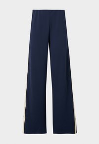 Pantalon large bleu marine en tissu doux, avec une bande beige sur le côté. La taille est élastique pour plus de confort et de facilité à porter.