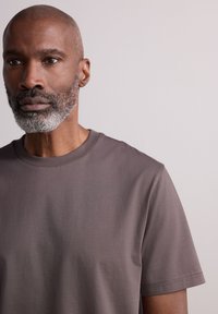 Grey short-sleeve t-shirt in soft, smooth fabric with a round neckline and relaxed fit, featuring no visible logos or designs.