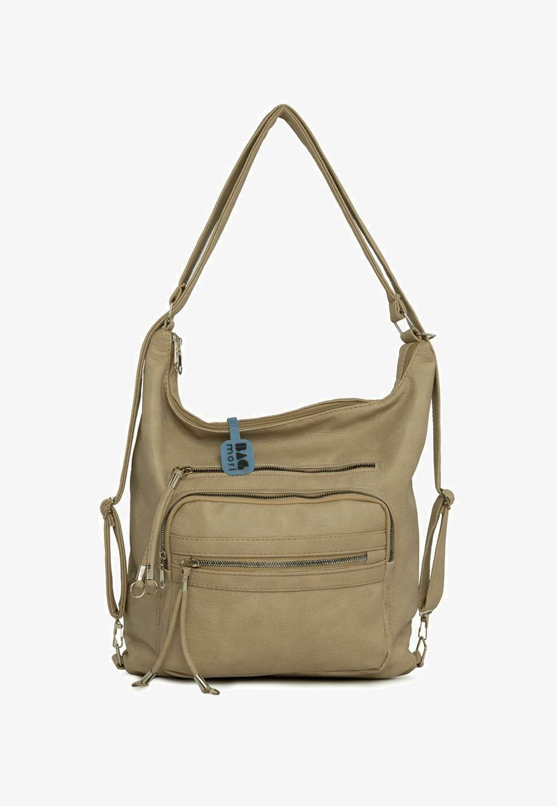 Sac à main en cuir souple beige avec plusieurs poches zippées, une bandoulière réglable et une étiquette bleue attachée à la fermeture éclair supérieure.