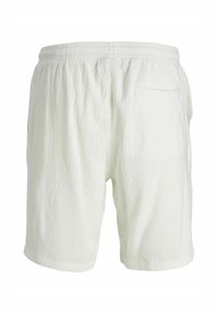 Shorts pour homme en tissu texturé blanc avec taille élastique et une poche arrière unique, présentés sur un fond uni.