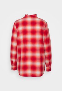 Czerwona i biała koszula w kratę z długim rękawem, zapinana na guziki przy mankietach i lekko falbaniastym kołnierzykiem, pokazana z tyłu na białym tle.