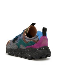 Baskets multicolores présentant un mélange de matériaux en daim et en maille, avec des accents gris, vert, bleu et violet, et une semelle texturée noire avec des éclaboussures.
