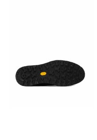 Suela de zapato de goma negra con un patrón de banda de rodadura resistente; presenta un emblema central amarillo para tracción y durabilidad.