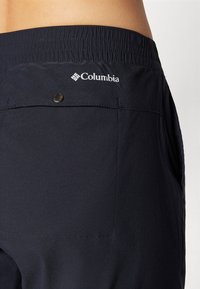 Mornarske plave Columbia kratke hlače od lagane tkanine, s elastičnim pojasom, gumbima kao ukrasima i logotipom na stražnjem dijelu.