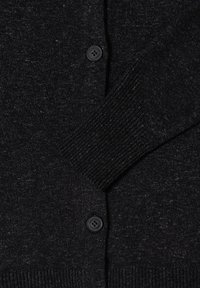 Schwarzer Cardigan mit strukturiertem Strickmuster, gerippten Bündchen und einem einzelnen schwarzen Knopfverschluss, der ein schlichtes Design und kontrastierende Texturen zeigt.