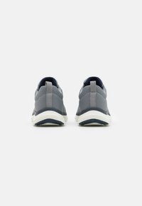 Gray athletic shoes with a breathable mesh upper, padded collar, and white rubber sole. Features a textured design and dark accents.