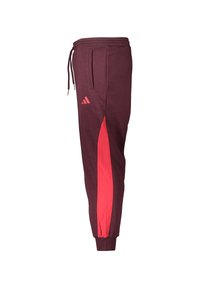 Bordeauxrode joggingbroek met een taps toelopende pasvorm, voorzien van een roze zijpaneel, een elastische tailleband en zakken. Versierd met een klein logo bij de heup.