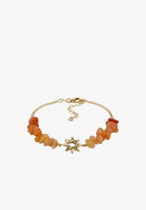 Goldenes Kettenarmband mit unregelmäßigen orangen Steinperlen und einem zentralen goldenen sonnenförmigen Anhänger mit hohlem Zentrum.