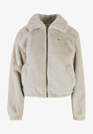 Világos bézs műszőrme dzseki cipzáros elülső résszel, túlméretes gallérral, gumírozott derékkal és oldalsó zsebekkel. Puha tapintás és laza stílus.