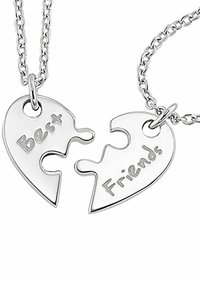 Silberne Puzzlestück-Halsketten, eine graviert mit "Beste" und die andere mit "Freunde", verbunden durch eine Kette, mit polierten Oberflächen.
