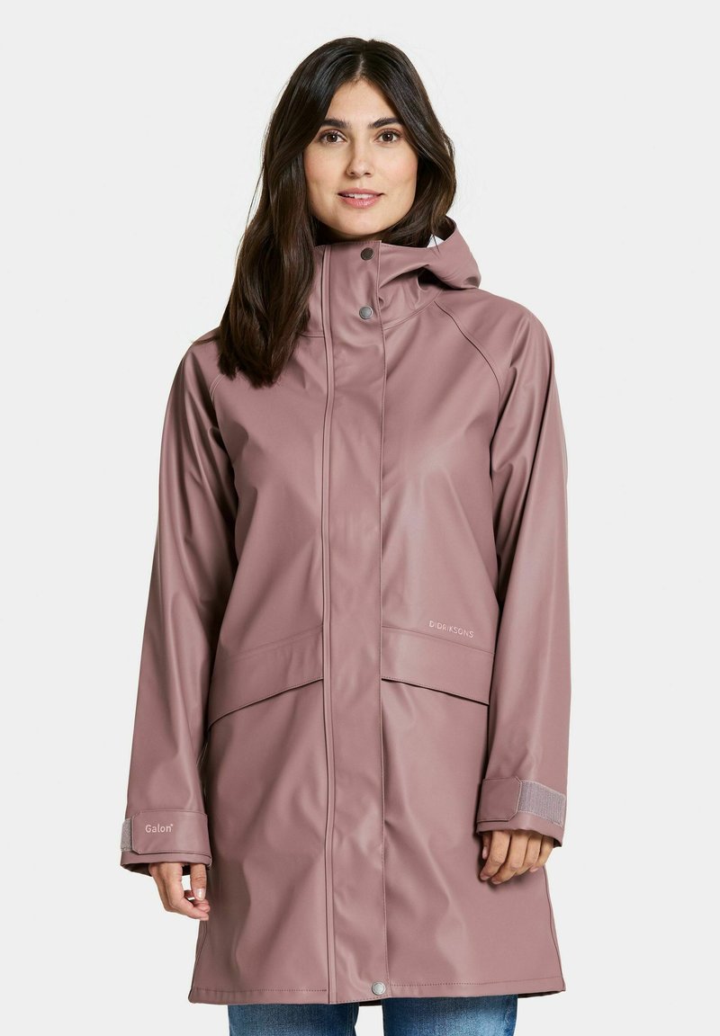 Vattentät rosa regnjacka med huva, utrustad med en framdragkedja, två stora fickor och justerbara mudd. Gjord av slät, hållbar material.