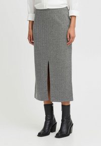 Szürke houndstooth midi szoknya elülső hasítékkal, textúrált szövettel. Fekete bőr bokacsizmával és fehér gombos inggel párosítva.