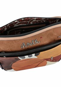 Hobo-Tasche mit braunem strukturiertem Äußeren, gemustertem Innenfutter und silbernen Beschlägen. Verfügt über zwei Reißverschlussfächer und grafische Designs.