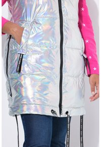 Holografische puffervest met een ritssluiting aan de voorkant, zijzakken en verstelbare trekkoorden. Heeft zwarte accenten en een gestructureerde stof.